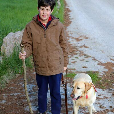 Measuring Quality of LIfe for those with ASD, starts with happiness. Boy walks a dog on a leash